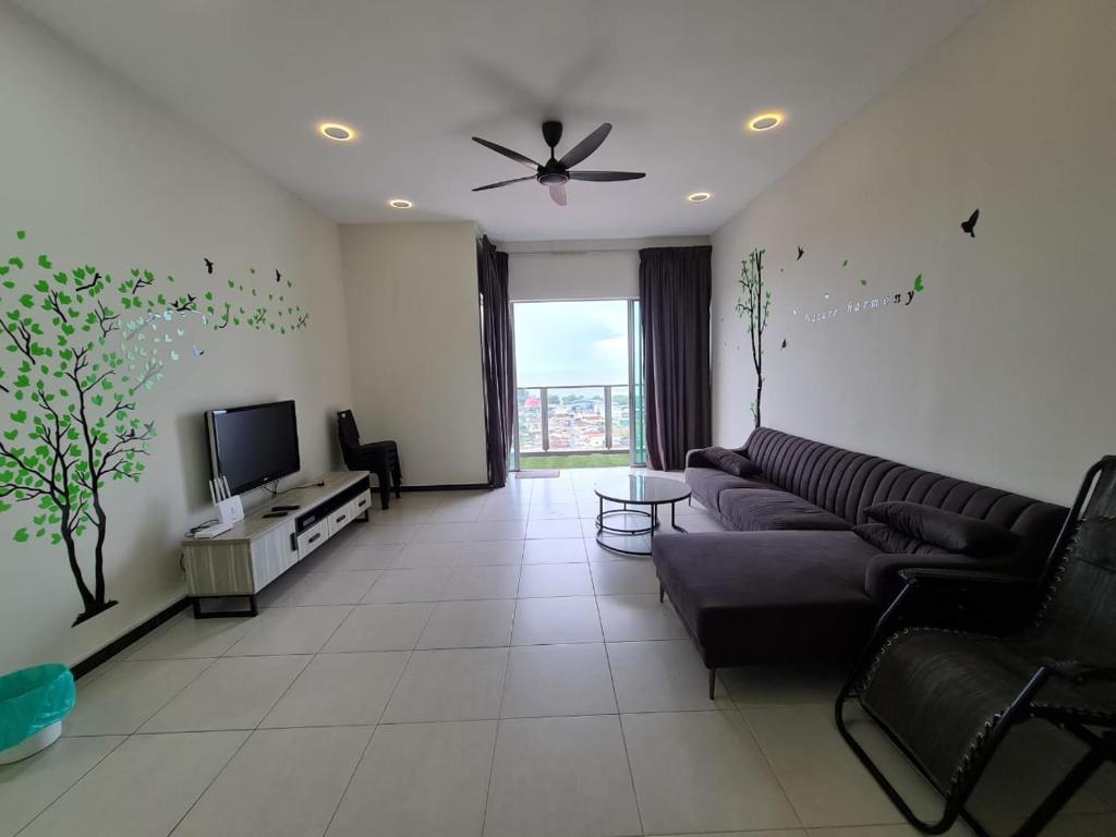 uma sala de estar com um sofá e uma televisão em Sekinchan Simple Love SeaHouse ~ Seaview 5-15B em Sekincan