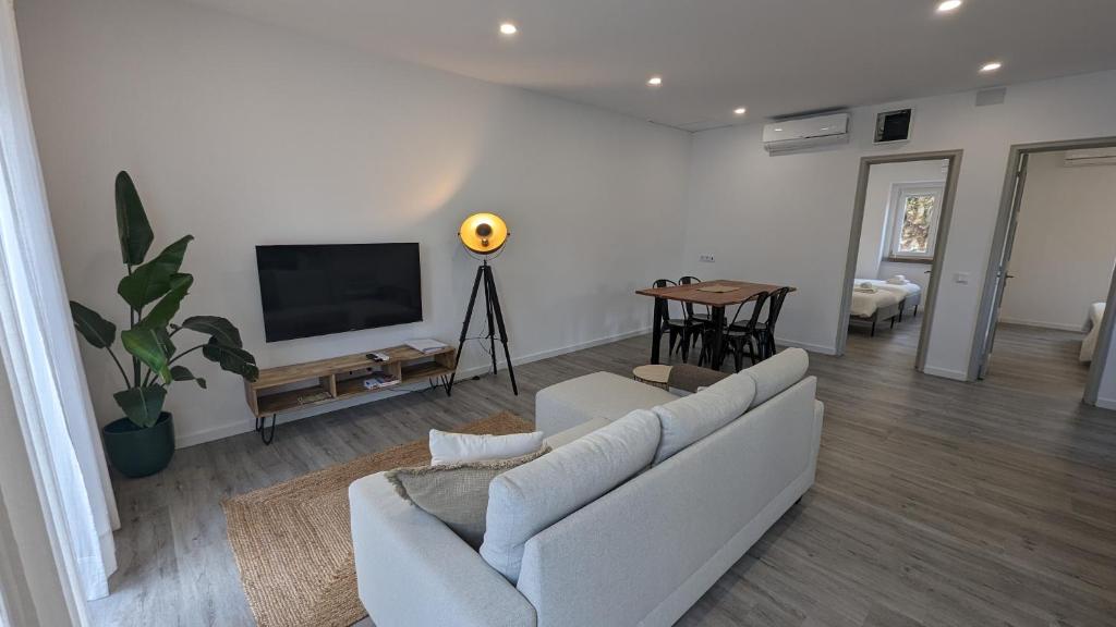 sala de estar con sofá y TV de pantalla plana en Golligo Apartments, en Sintra