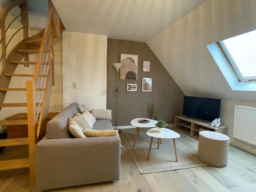 a living room with a couch and a staircase at Coup de cœur~Duplex cocoon vue sur le beffroi -Top Séjour Arras in Arras