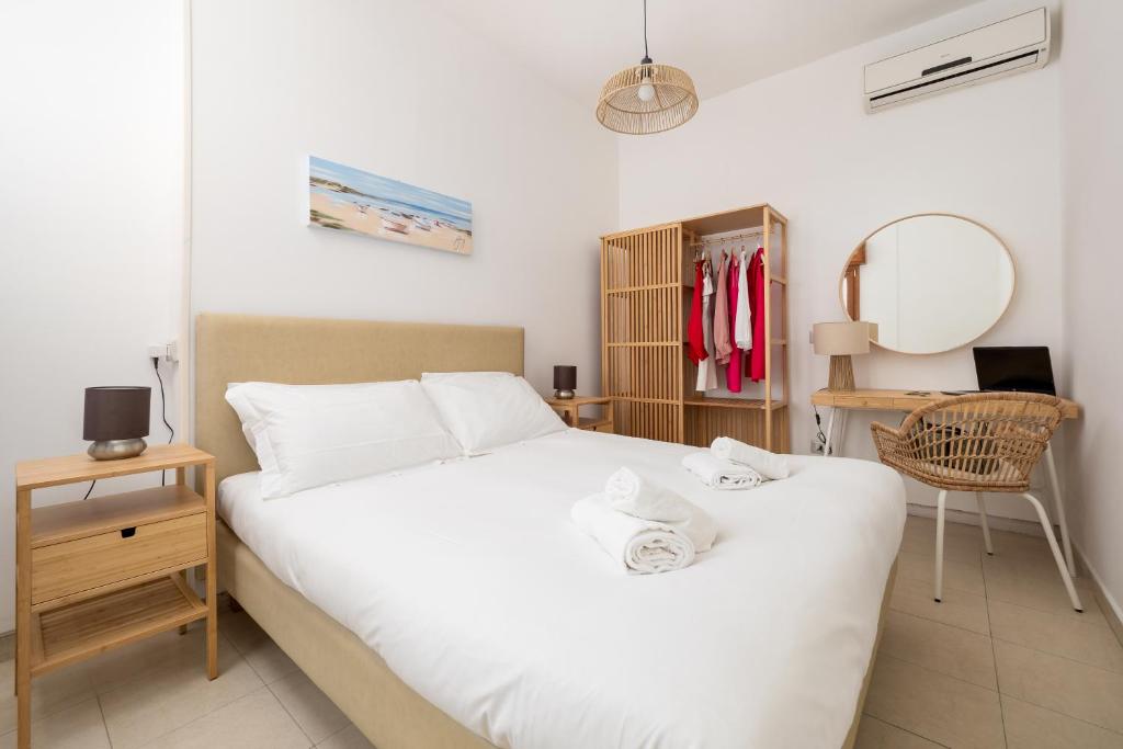 Un dormitorio con una gran cama blanca y un espejo. en Rossella Holiday Home, en Sorrento