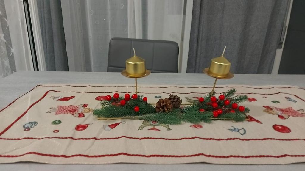 a table with a christmas centerpiece with two candles at House Arrow in Latina