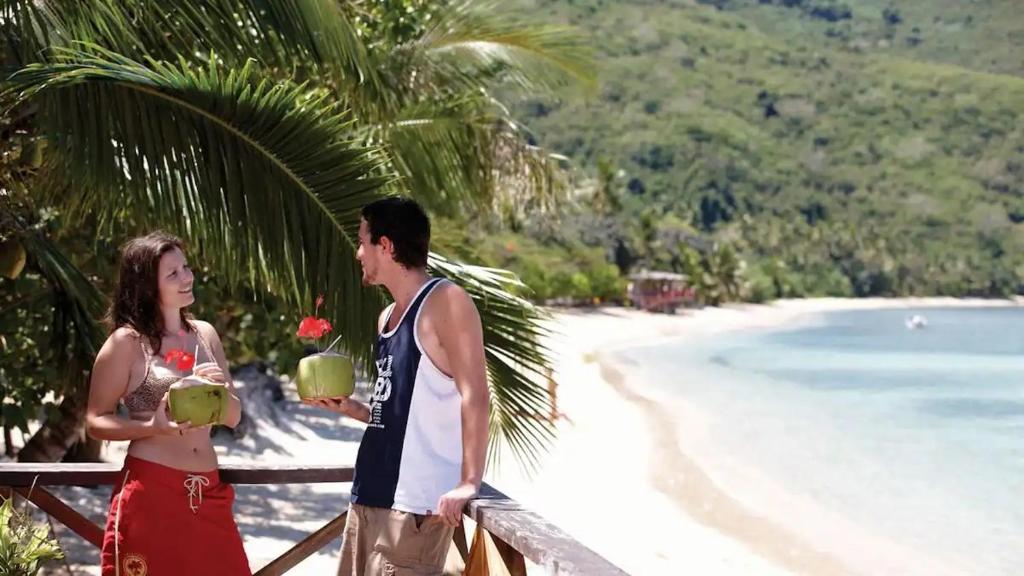 een man en vrouw die naast een strand staan bij White Sandy Beach-Best Manta Snorkeling in Naviti Island