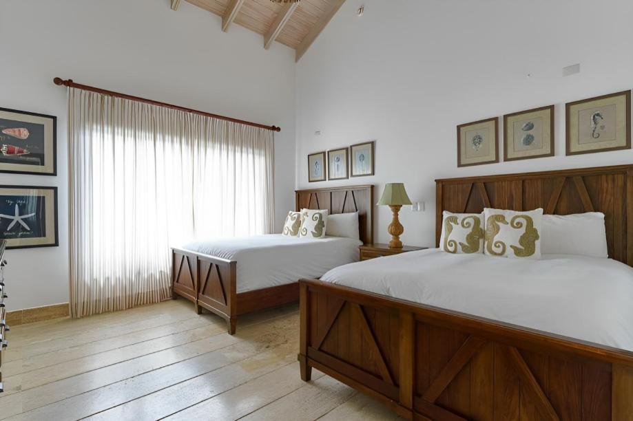 璜多里奧的住宿－Majestuosa villa en Juan Dolio, Guavaberry Golf & Country Club，一间卧室设有两张床和窗户。