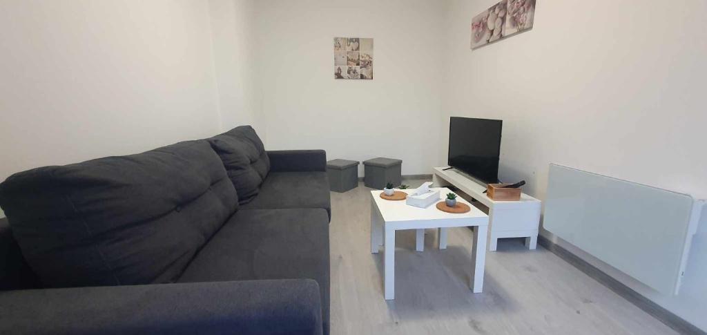 a living room with a couch and a table at Maison à 500 m du lac in Ardres