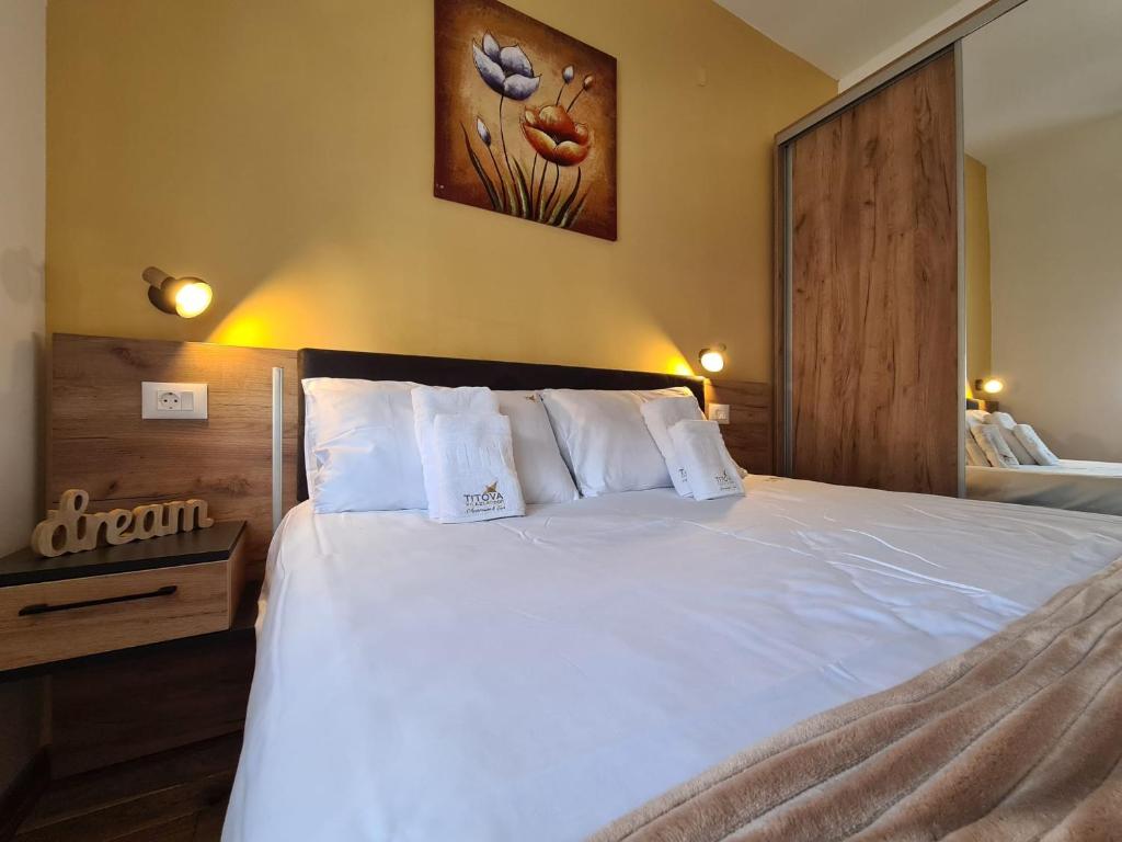 - une chambre avec un lit doté de draps et d'oreillers blancs dans l'établissement Apartman Rajska dolina Titova vila, à Palisat