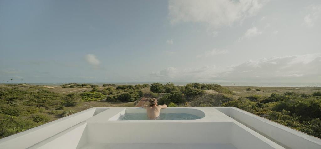 eine Person in einer Badewanne auf dem Dach eines Gebäudes in der Unterkunft Casa Attico - Design Beach House in Touros