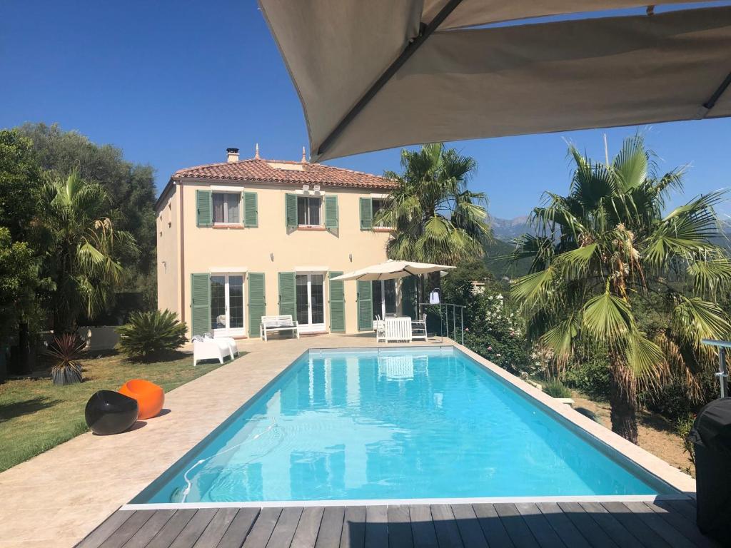 une piscine devant une maison dans l'établissement AU MOULIN CARLOTTA - Villa luxe Corse, à SERRA DI FIUMORBO
