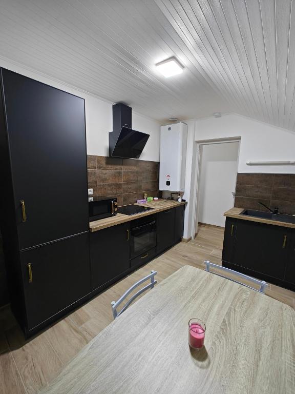 a kitchen with black cabinets and a table in a room at Appartement proche du centre in Thonon-les-Bains