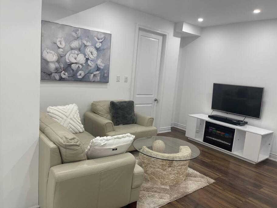 een woonkamer met een bank en een tv bij luxury & Spacious 2 bedrooms serviced apartment in Brampton