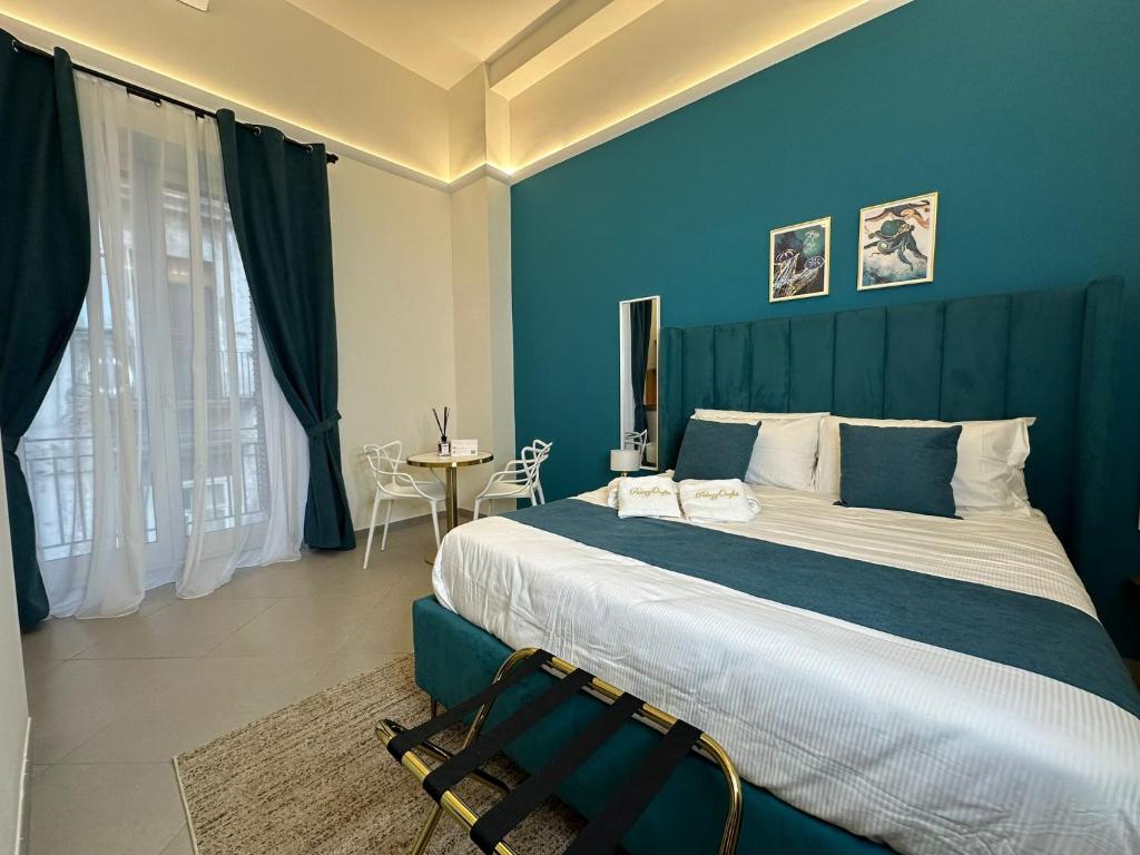 una camera da letto con un grande letto con pareti blu di PALAZZOREFICI a Napoli