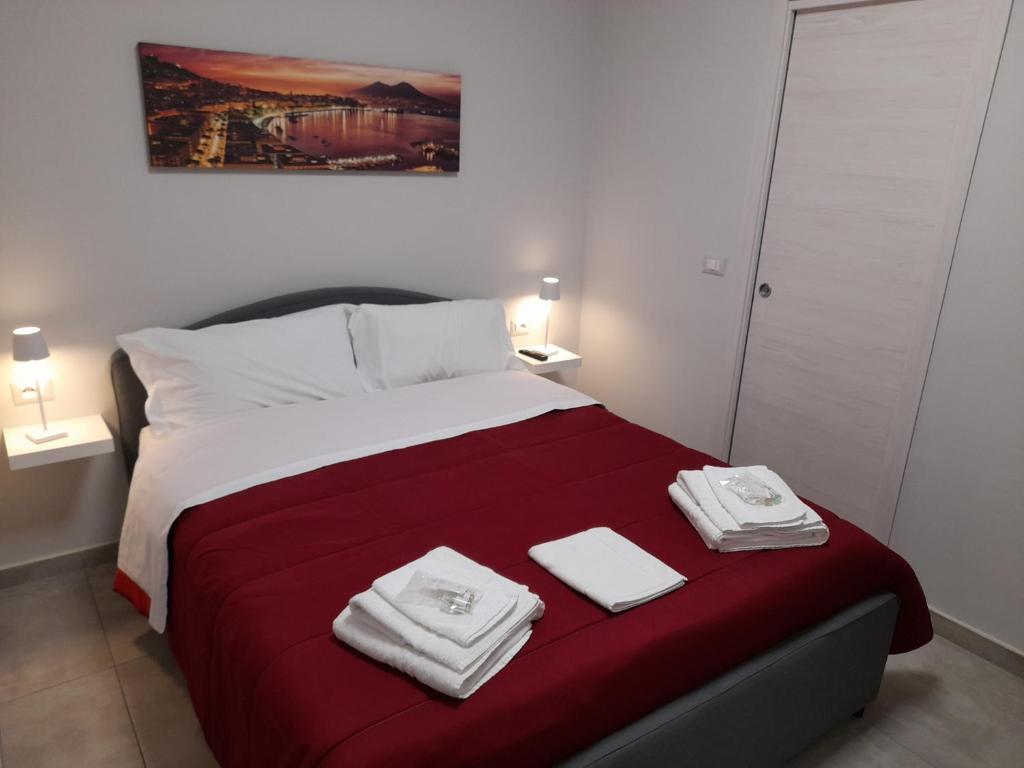 una camera da letto con un letto e due asciugamani di MOM'S HOUSE VOMERO a Napoli