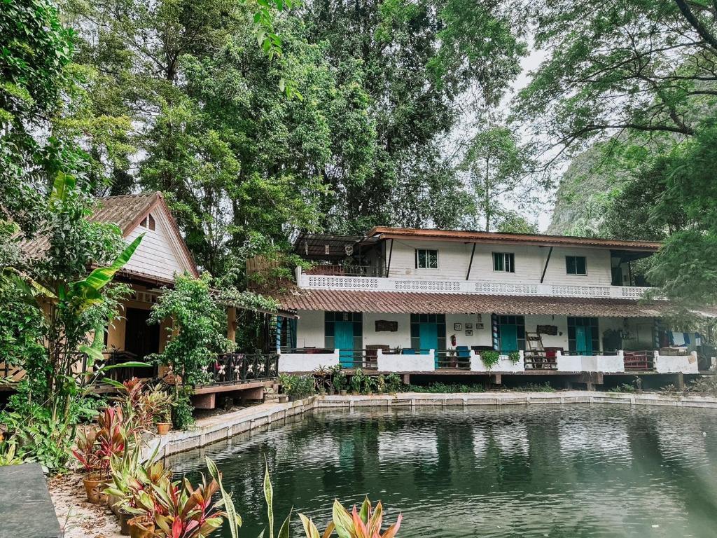 ein Haus mit einem Teich davor in der Unterkunft Baan Suanthip Homestay - Aoluek Natural Retreat in Ao Luk