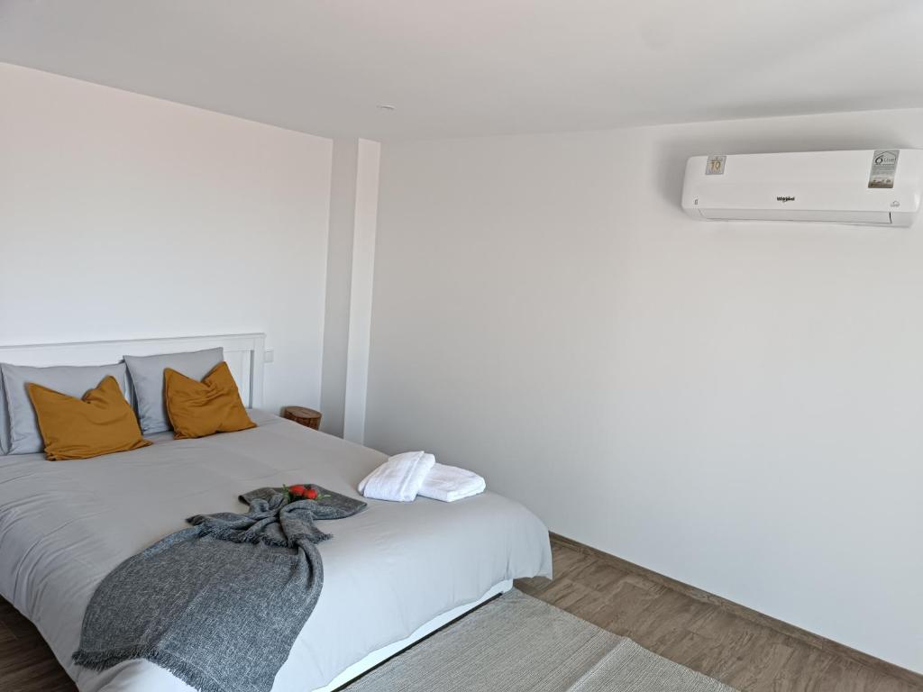 ein Schlafzimmer mit einem weißen Bett und orangefarbenen Kissen in der Unterkunft Casa Nova de Senradelas in Marco de Canavezes