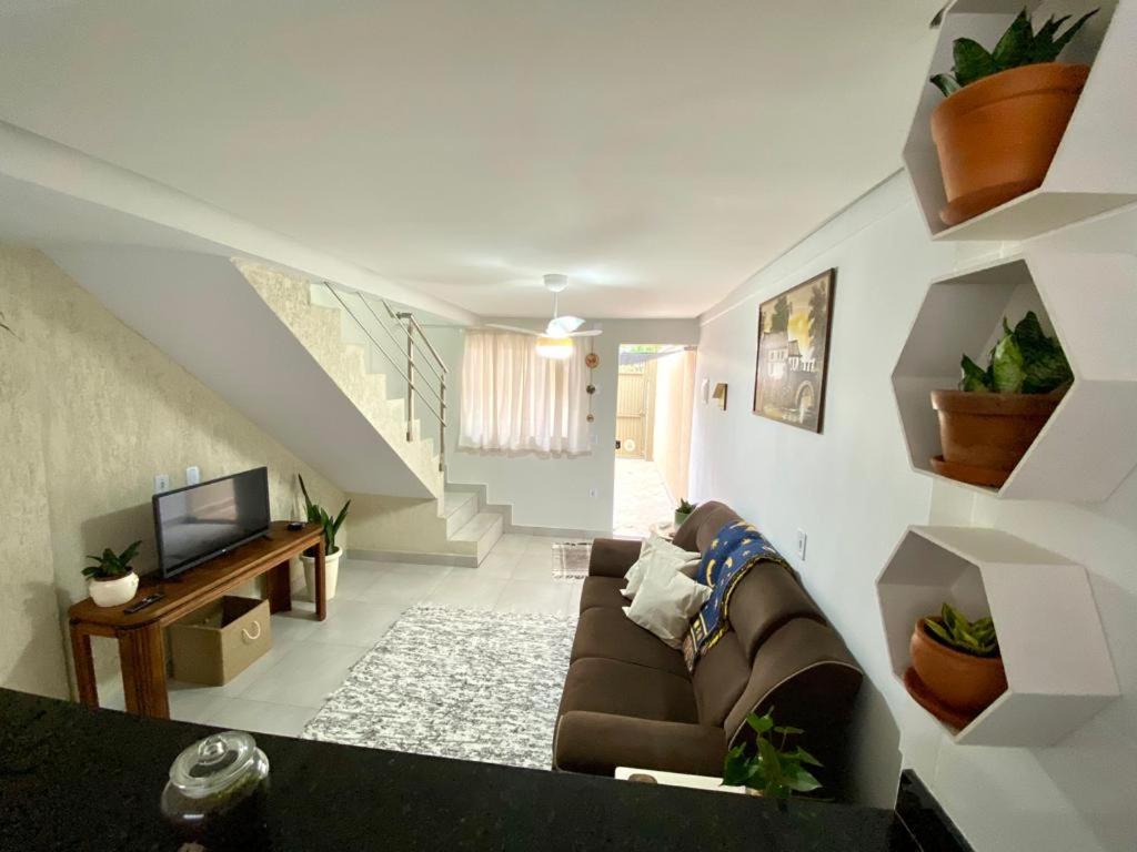 uma sala de estar com um sofá e uma televisão em Refugio Urbano em Goiânia