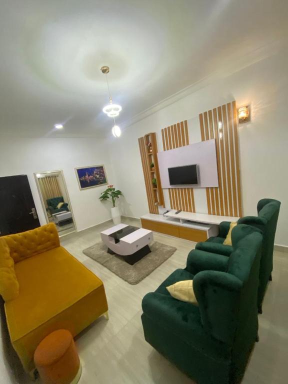 a living room with a green couch and a tv at Excel suite by Home Glides in Lekki