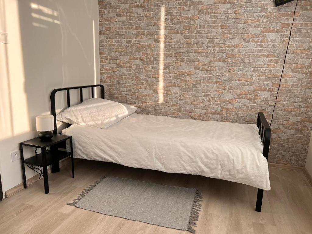 a bed in a room with a brick wall at Stella Apartment in Lamač