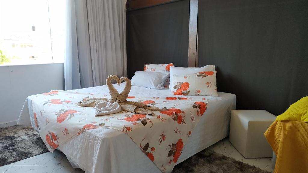 un dormitorio con una cama con un animal de peluche en Suítes Maravilha Arraial do Cabo en Arraial do Cabo