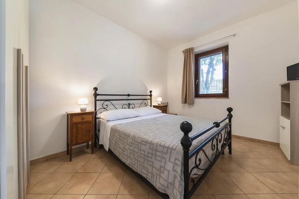 a bedroom with a large bed and a window at Casetta Nociarelle in Piegaro