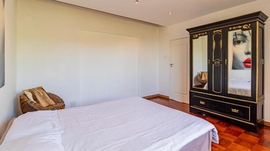 een slaapkamer met een bed en een dressoir bij The View in Kaapstad