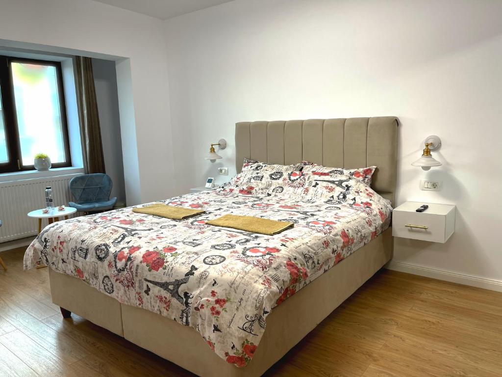 特爾古日烏的住宿－Lucky 13 Studio，一间卧室配有一张带花卉棉被的床