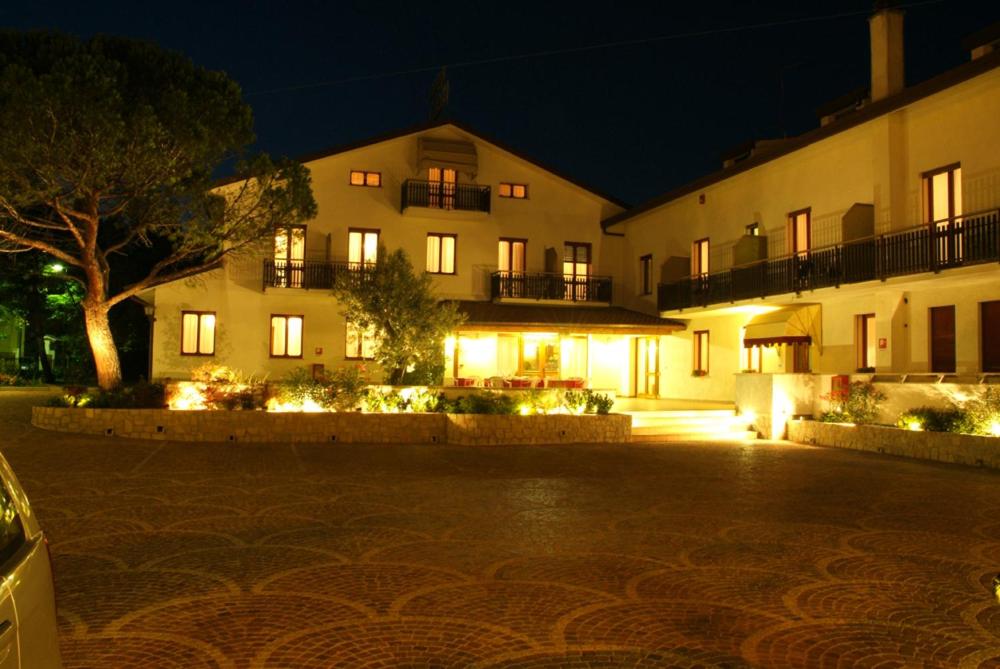 a large building with lights in front of it at night at Hotel Alla Dolina in Sistiana