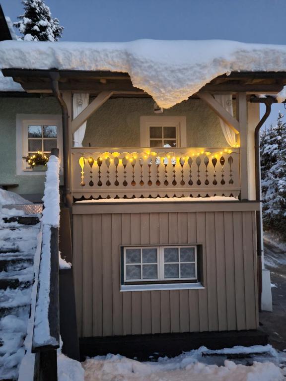 a house with a balcony with christmas lights on it at Ferienhaus Forsthof in Taxenbach