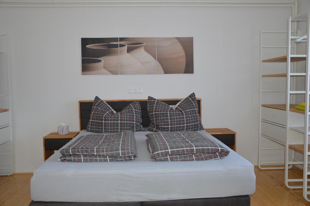 a bed with four pillows and a picture above it at Kinderlachen garantiert in Lutzmannsburg