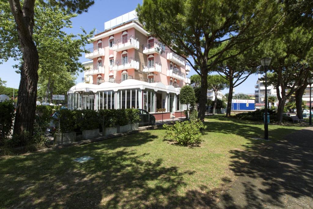 un edificio rosa con árboles delante en Hotel El Paso, en Lido di Jesolo
