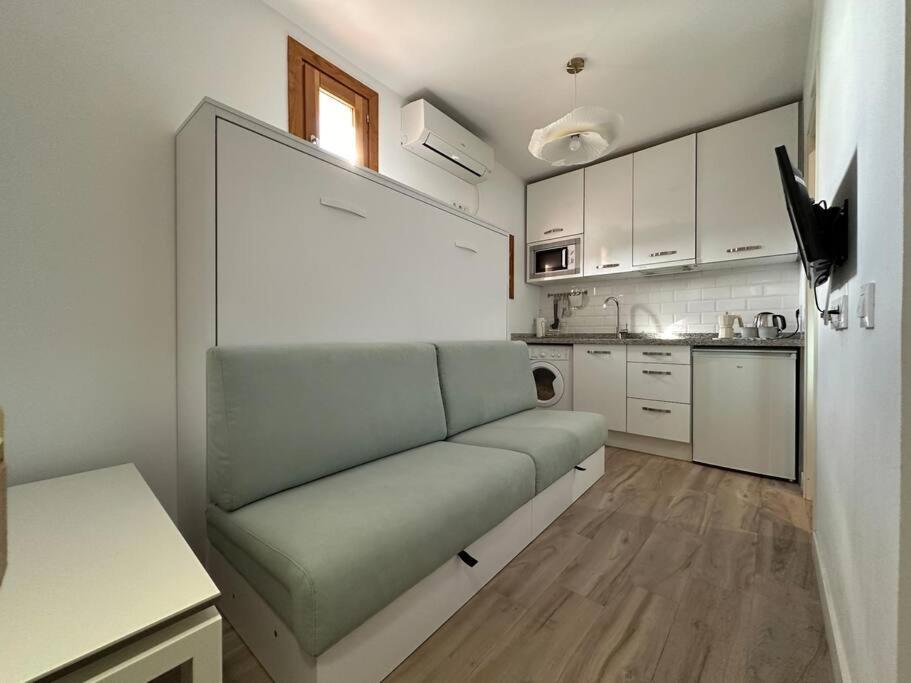 uma sala de estar com um sofá na cozinha em Tu estudio en el centro de Madrid em Madri