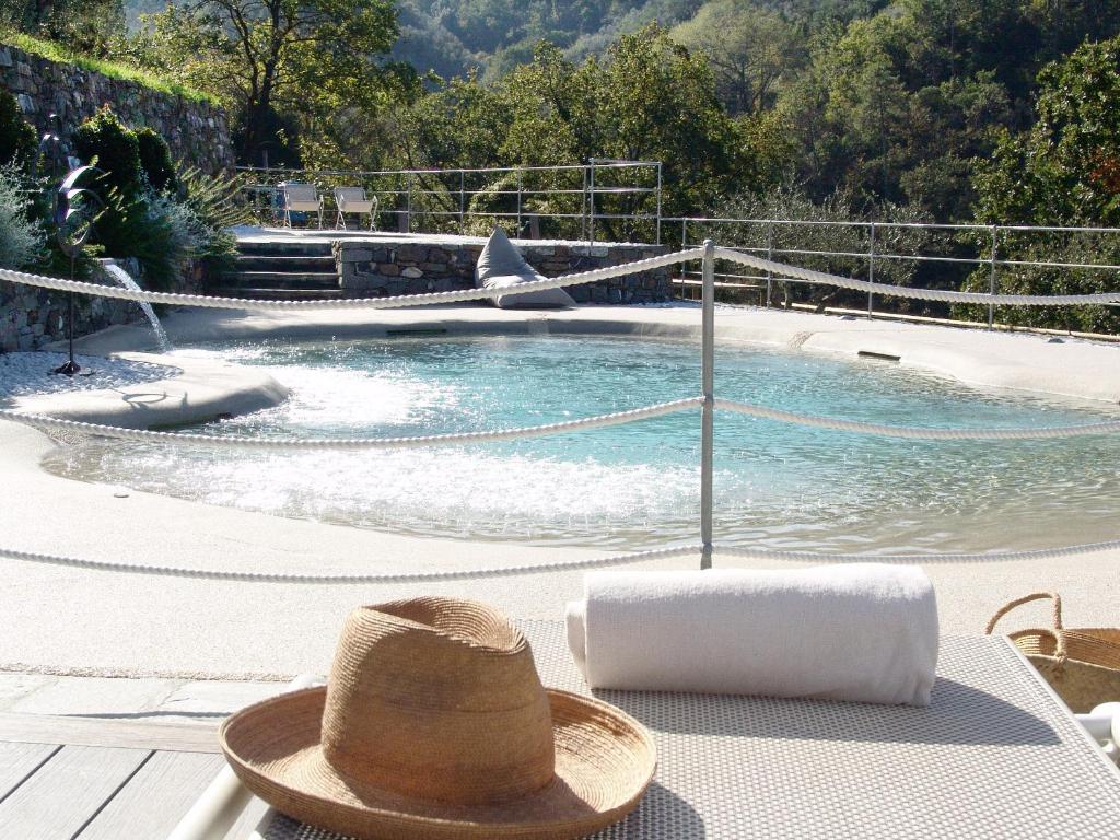 un sombrero sentado en una mesa junto a una piscina en Villanova - Nature & Wellness, en Levanto