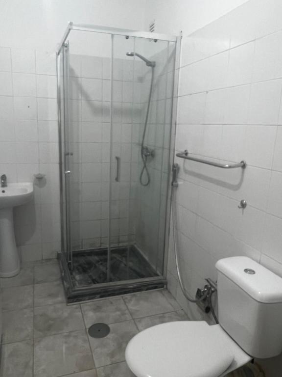 a bathroom with a shower with a toilet and a sink at Apartamento in Praia