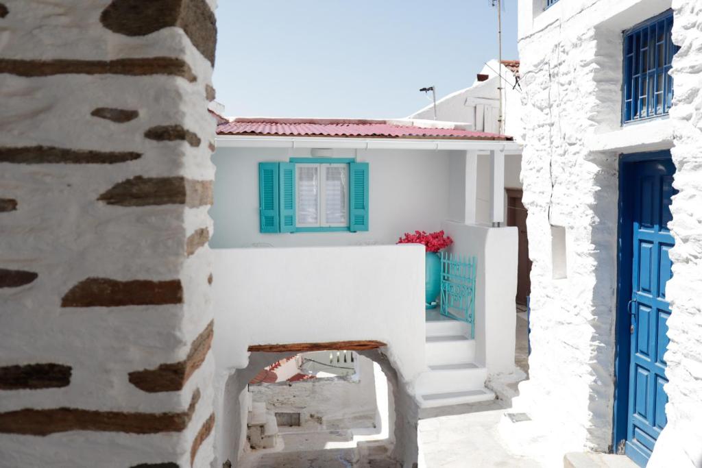 a view of a white building with blue doors at The Turquoise House in the heart of Ioulida, on the island of Kea. in Ioulis
