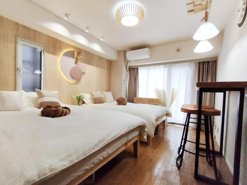 a hotel room with two beds and a window at S31 Shibuya center 7 mins to Station, Max 4P涉谷最中心 涉谷站7分-S 直达表参道 池袋 上野 代代木 银座 原宿 in Tokyo