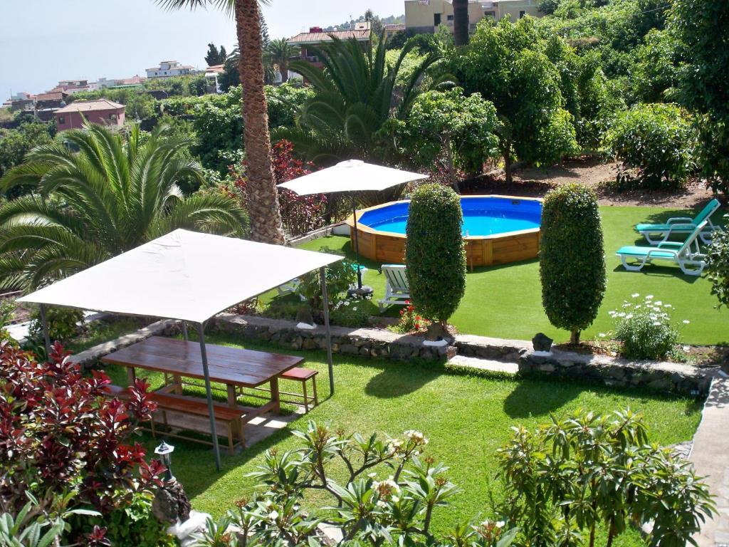 un jardín con sombrillas y una piscina en Casa Rural La Furnia, en Icod de los Vinos