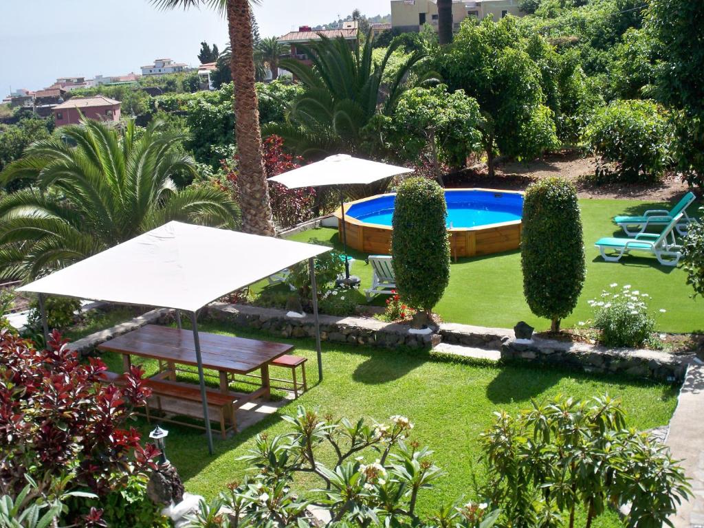 イコー・デ・ロス・ビノスにあるCasa Rural La Furniaのパラソル付きの庭園、スイミングプールを提供しています。