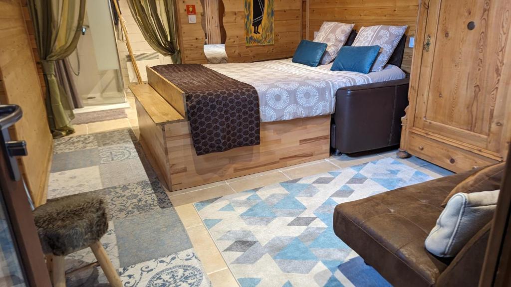 a small room with a bed and a couch at Les Chambres D'oriane in Chessy
