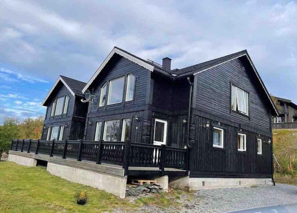 una casa negra con techo negro en Feriehus med ti senger på Skaidi en Hammerfest