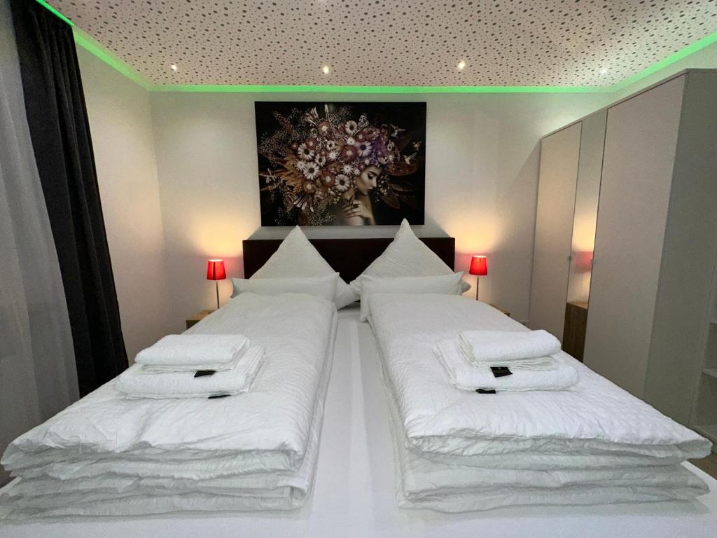 a bedroom with two beds with white sheets at Modern Apartments Neuburg 2 - TOP NEU - 2 Zimmer, Komfort, Balkon, Wi-Fi, Smart TV, Dusche, Küche in Neuburg an der Donau