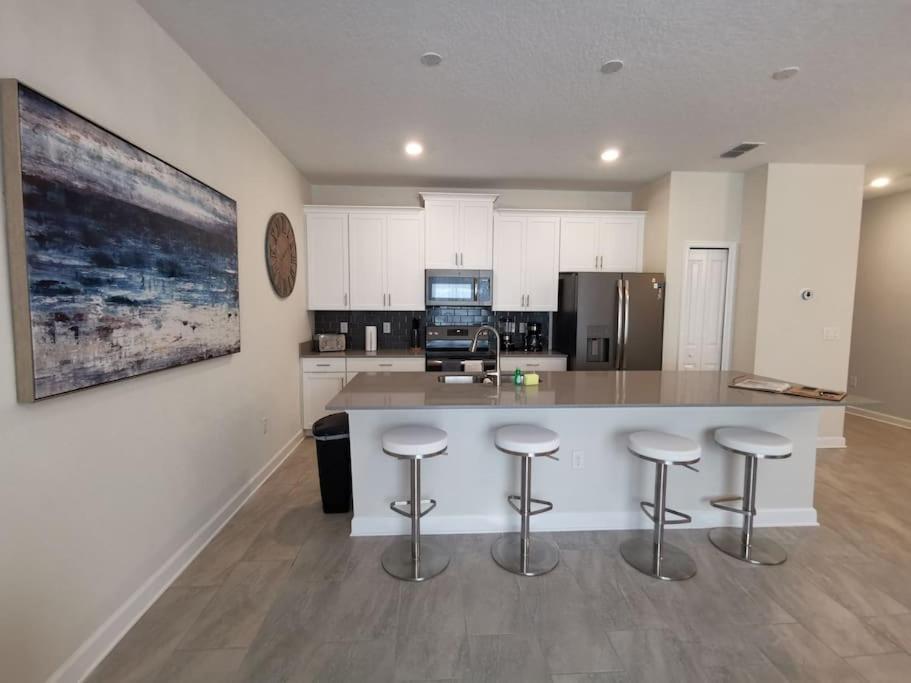 een keuken met een groot eiland met barkrukken bij Makin Memories Gated Resort Style Community Storey Lake in Kissimmee