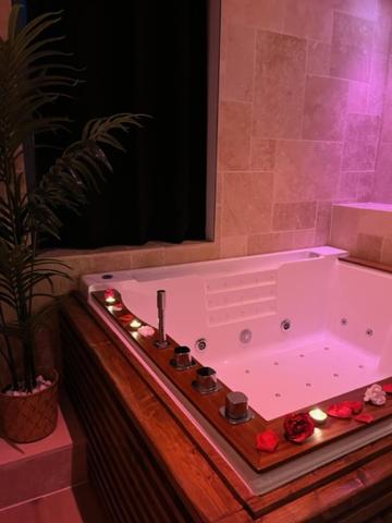 una bañera blanca con luces en el baño en Bella Notte Spa en Dijon