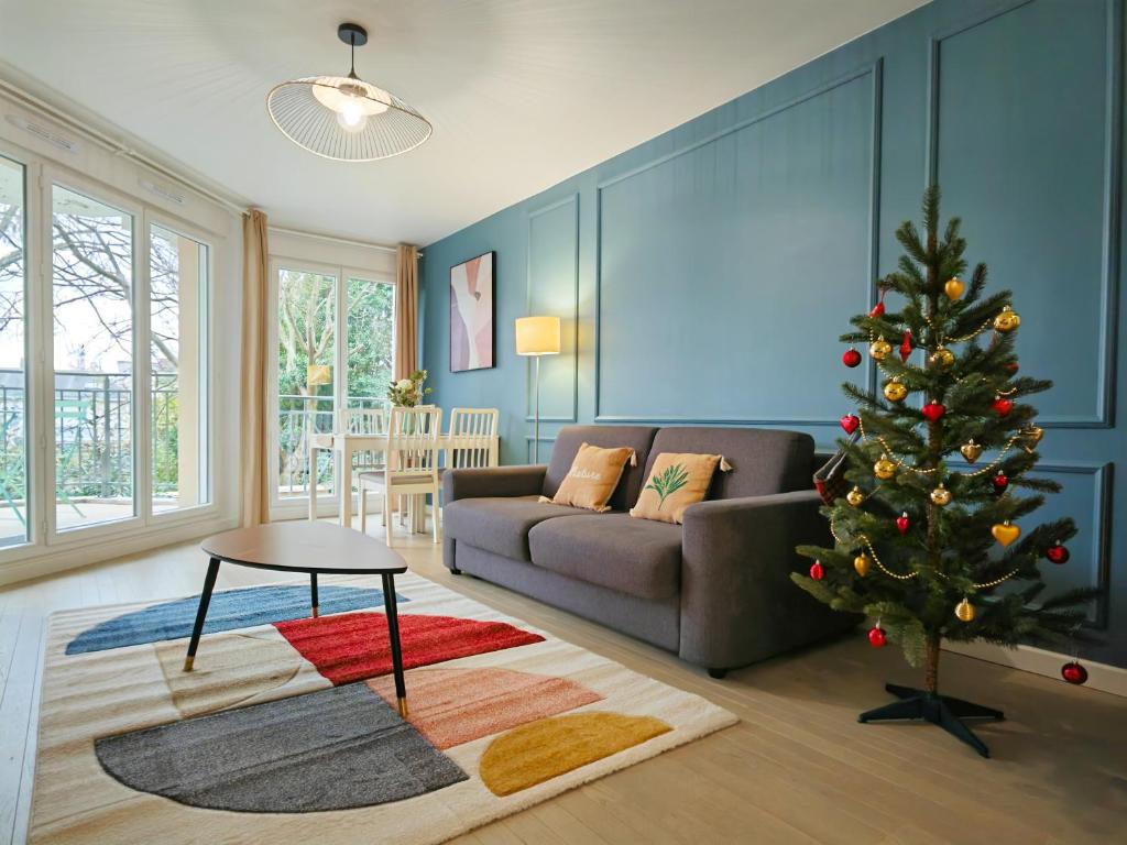 ein Wohnzimmer mit einem Weihnachtsbaum und einer Couch in der Unterkunft Maison de Charme - parking gratuit près de Paris & métro in Villejuif