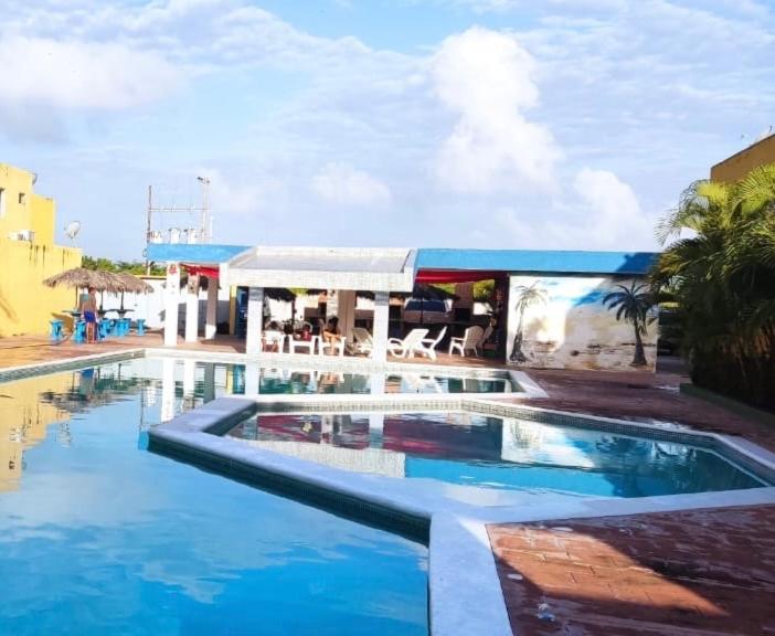 una piscina de agua azul frente a un edificio en Apartamento Playa Ciudad Flamingo Tucacas Chichiriviche en Tucacas