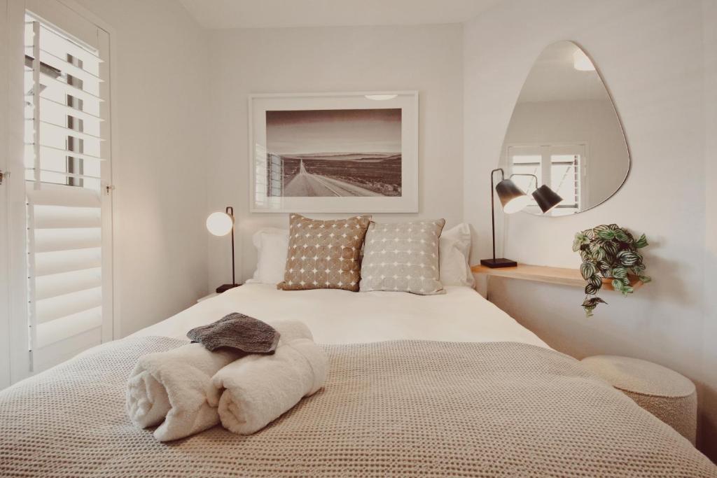 a bedroom with a white bed with a large mirror at Luxury on Dorp in Stellenbosch