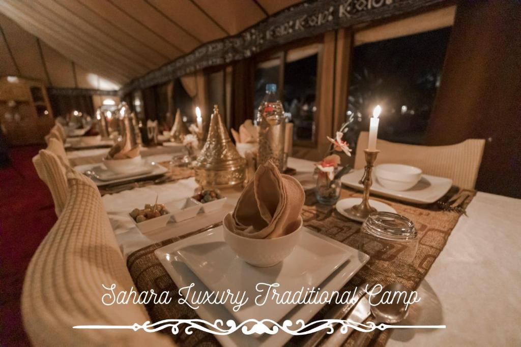 una mesa larga con un plato de comida. en Sahara Luxury Traditional Camp, en Merzouga