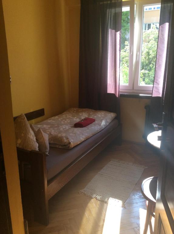małe łóżko w pokoju z oknem w obiekcie mika rooms - 22 Korotynskiego Street w Warszawie