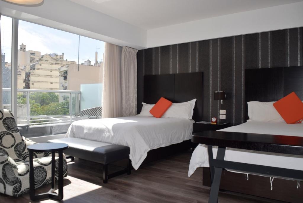 een hotelkamer met 2 bedden en een piano bij Hotel BA Abasto in Buenos Aires