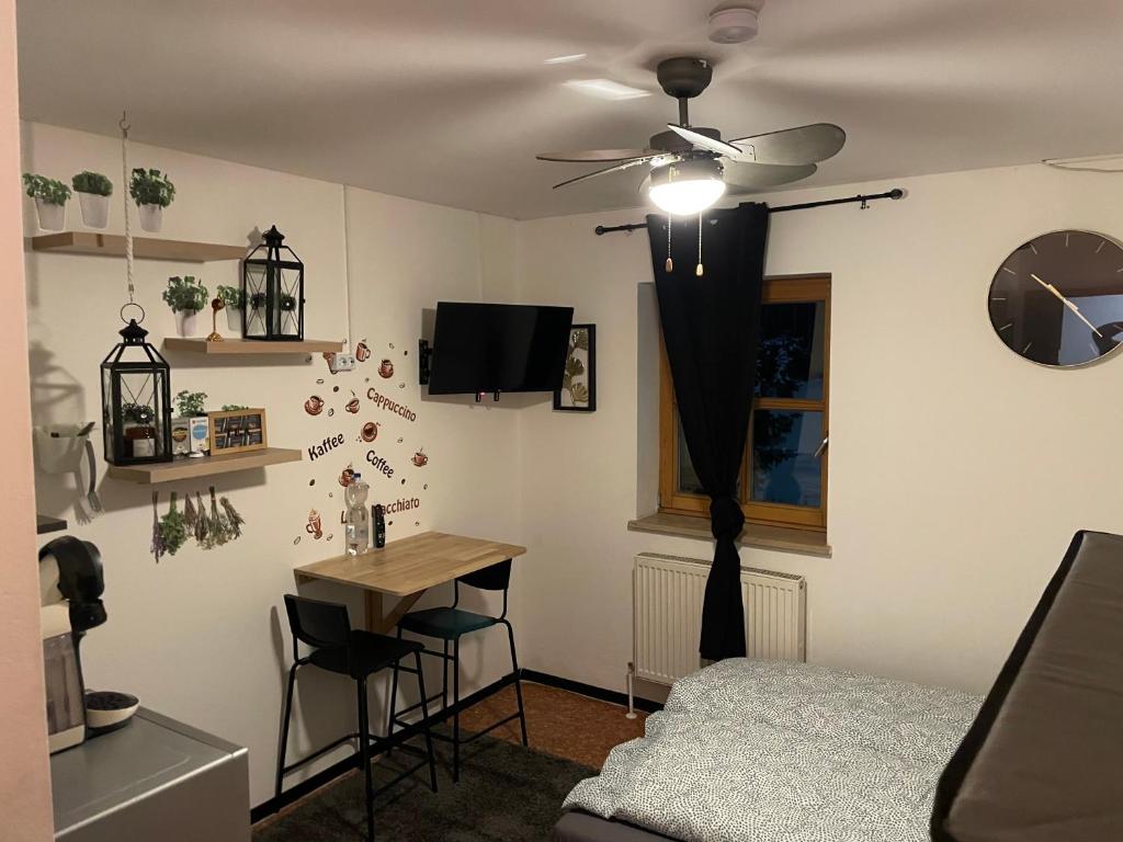 a bedroom with a ceiling fan and a table at Vilseck Apartment in Vilseck