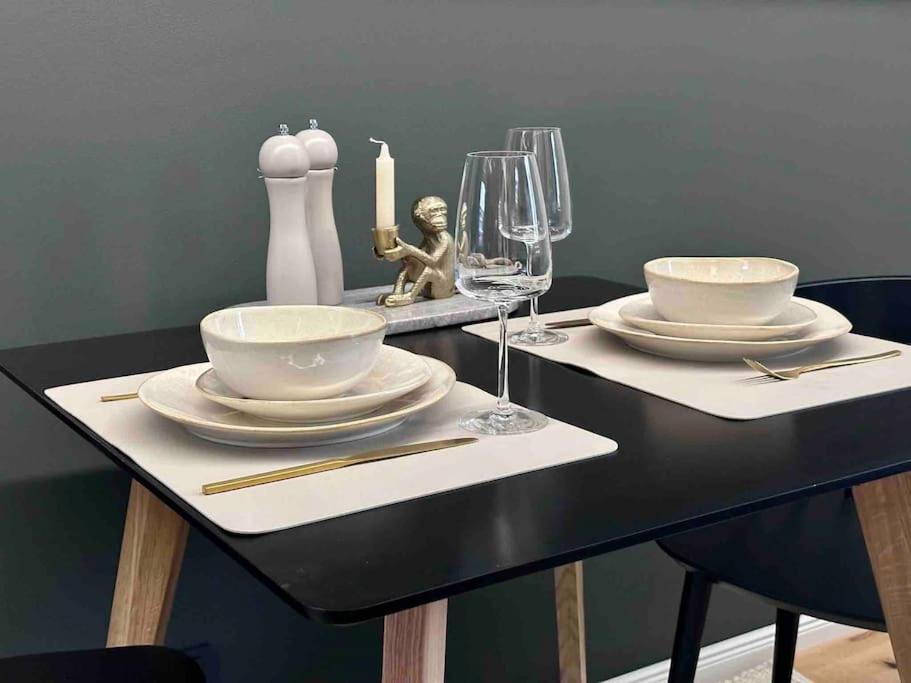 uma mesa preta com pratos, copos e velas em Premium Apartment mit Domblick im DG em Paderborn