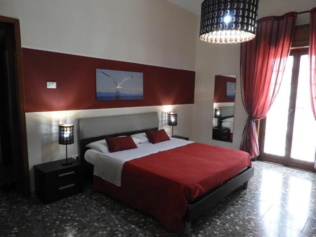 1 dormitorio con 1 cama grande con manta roja en Oleandro e Glicine, en Lecce