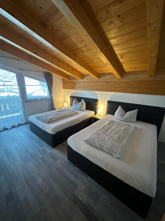 2 camas en una habitación con techos de madera en LEO Apart 1, en Radfeld